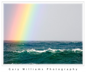 Photograph of a rainbow over the ocean at Pacific Grove, California