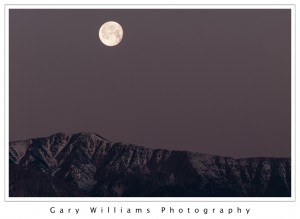 Photograph of a full moon setting over Telescope Peak, Death Valley National Park