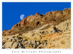 Photograph of the moon behind rugged rocks at Red Rock State Park, California